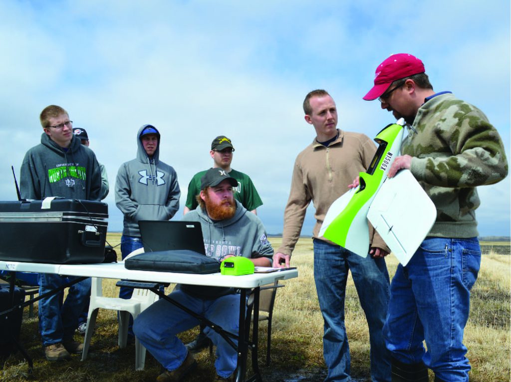 Instructor teaching students with drones in the field